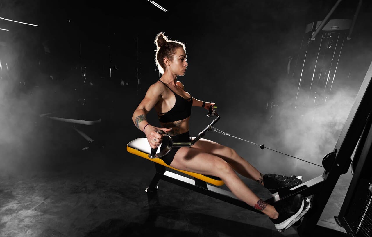 garota-atletica-faz-exercicios-usando-equipamentos-esportivos-em-uma-academia